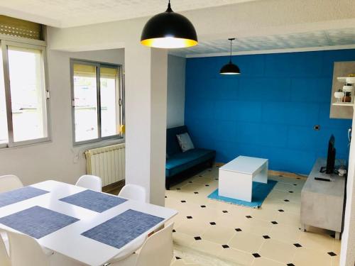 普埃托利亚诺Acogedor apartamento muy cerca del centro的一间设有白色桌子和蓝色墙壁的用餐室