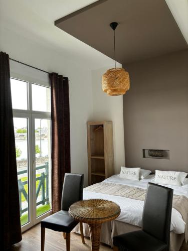 索米尔Rive Gauche的卧室配有一张床和一张桌子及椅子