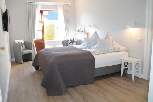 UtersumLandhaus Nordstern Hotel garni的白色的卧室设有床和窗户