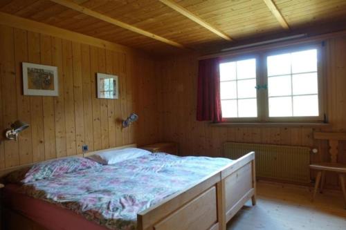 迪森蒂斯Bündnerchalet im Herz der Schweizer Alpen的木制客房内的一间卧室,配有一张床