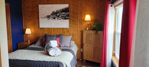 佩尔塞Gîte Aux Jardins De L'Anse的一间卧室设有一张床和木墙
