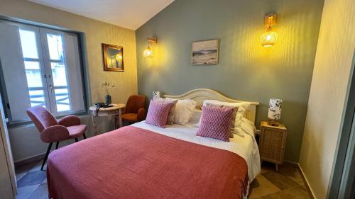 博尼法乔Colomba Hôtel Centre-Ville Historique的卧室配有一张带粉红色枕头的大床
