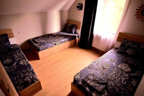 博尔若米RESORT WEEKEND BoRJOMI的小房间设有两张床和窗户