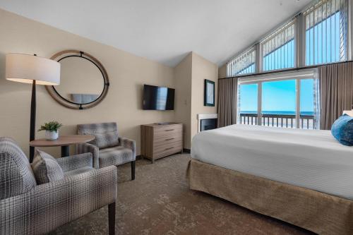卡农海滩帆船湾酒店的一间卧室设有一张床和一个大窗户