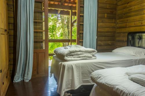 坎博里乌Fazenda dos Caetés的木间设有两张床,设有窗户