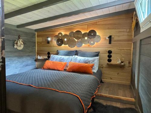 Échenoz-la-MélineTiNY HOUSE LE CHALET的卧室配有一张床铺,位于带木墙的房间内