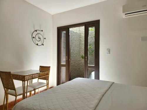 卡波布里奥Pousada Porto Fino的一间卧室配有一张床、一张桌子和一个窗户。