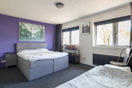 希佛萨姆Beautiful house n.Amsterdam, suitable for families的一间卧室设有两张床和紫色的墙壁