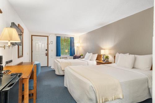 布兰森Autumn Creek Branson的酒店客房配有两张床和一张书桌