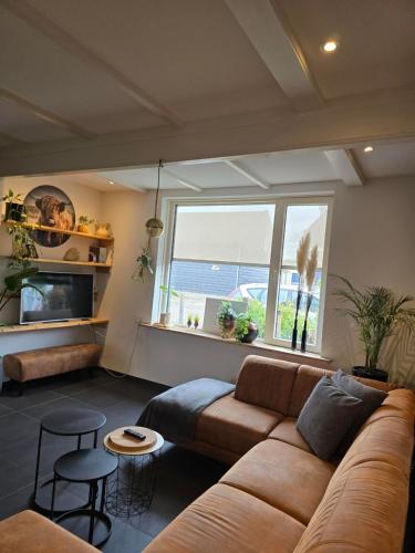 弗利辛恩Tip Top Studio Vlissingen的带沙发和大窗户的客厅