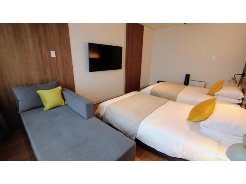 鸳泊Rishiri Fuji Kanko Hotel - Vacation STAY 63401v的酒店客房,设有两张床和一张沙发