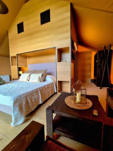 蒙苏姆马诺Glamping Suite Rosso Baccara的一间卧室配有一张大床和一张桌子