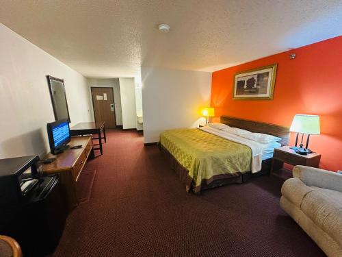 West FargoStudio 7 on Main的配有一张床和一台平面电视的酒店客房