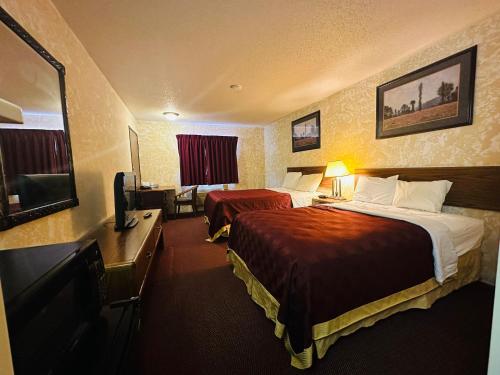 West FargoStudio 7 on Main的酒店客房设有两张床、一张桌子和一台电视。