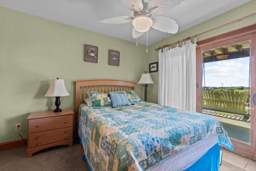 纳格斯黑德5711 - OBX Ta SEA by Resort Realty的一间卧室配有一张带吊扇和窗户的床。