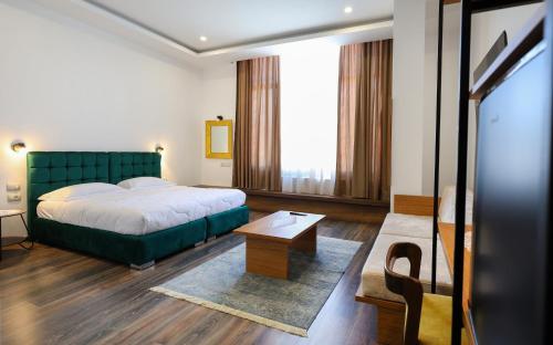 培拉特Hotel Republika Berat的酒店客房配有一张床铺和一张桌子。