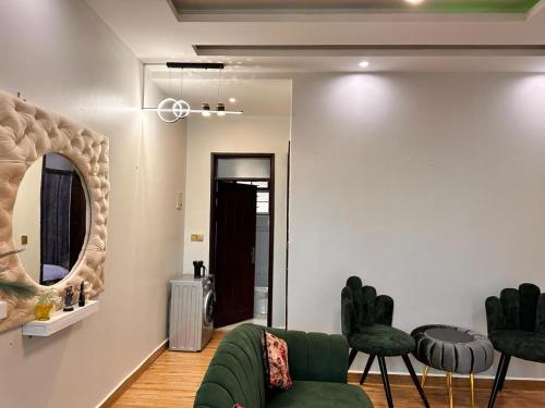 KiraLyrrh Homes Apartments的客厅配有绿色沙发和镜子