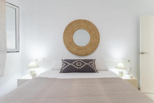 哈维亚Chalet independiente a 50 metros de Cala Blanca的卧室配有一张壁挂镜子的床