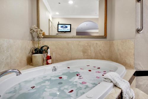 丹纳岬丹纳岬贝斯特韦斯特滨海海岸酒店的浴室配有带鲜花的浴缸。