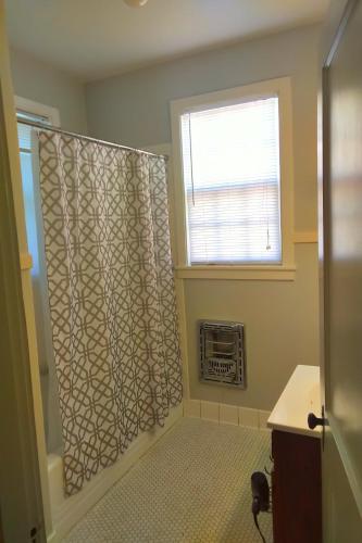 琼斯伯勒Urban Retreat on Flint的带淋浴帘和窗户的浴室
