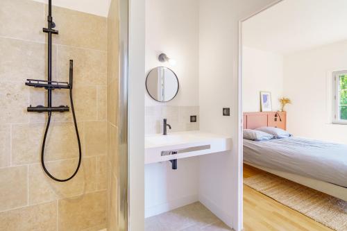 比亚里茨La Conciergerie Biarritz的带淋浴和盥洗盆的浴室以及1张床。