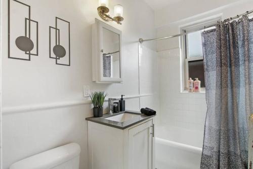 芝加哥2BR Cozy and Furnished Apt in Hyde Park - Hyde Park 405的白色的浴室设有水槽和淋浴。