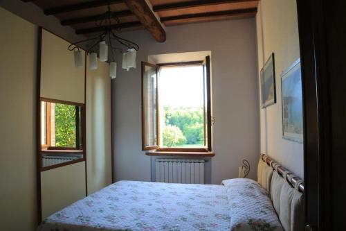 锡耶纳“Il Nespolino” Tuscan Country House的一间卧室设有一张床和一个窗口