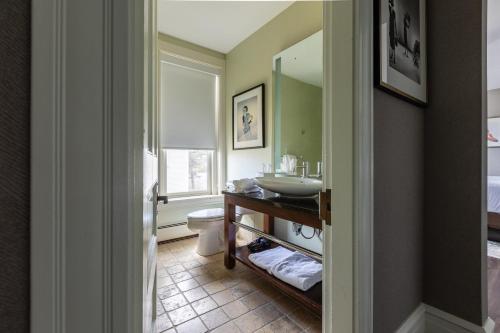 康科德森特尼尔酒店的一间带水槽、卫生间和镜子的浴室