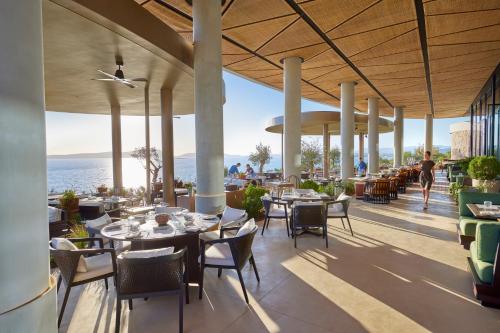 皮洛斯Mandarin Oriental, Costa Navarino的一间带桌椅的海景餐厅
