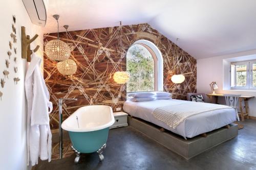 法蒂玛卢斯迷人乡村民宿的卧室配有床、浴缸和窗户。