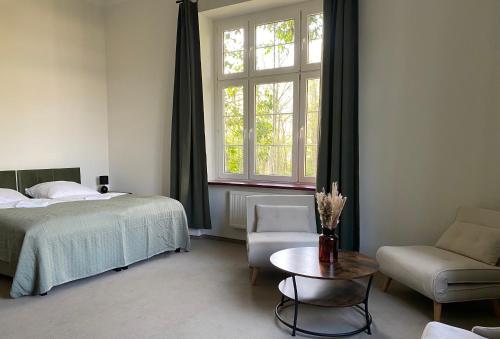 韦巴Zamek Nowęcin的卧室配有1张床、1张桌子和1把椅子