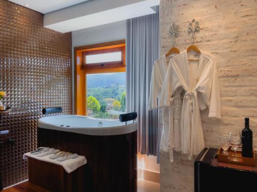 蒙特韦尔迪Hotel Harmonia Monte Verde的带浴缸的浴室和窗户。