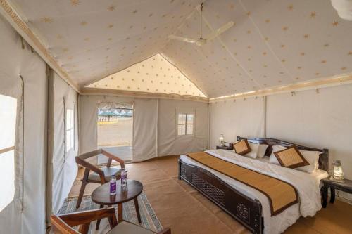 斋沙默尔Royal Rangers Desert Safari Camp的卧室配有一张床和一张桌子