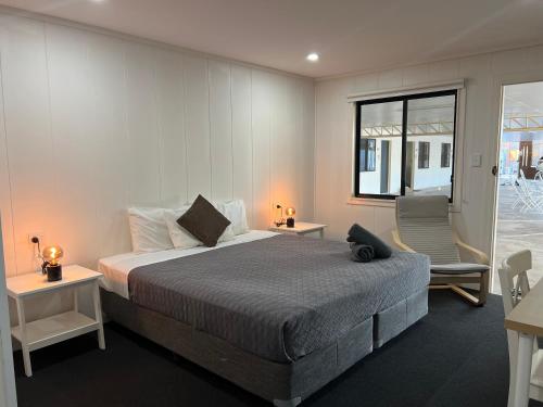 朗里奇Abajaz Motel-Centrally Located-Shaded Parking的卧室配有床、椅子和窗户。