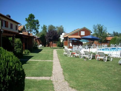 米娜克拉韦罗Complejo Cantonavi的一个带椅子的庭院、一个游泳池和一个房子