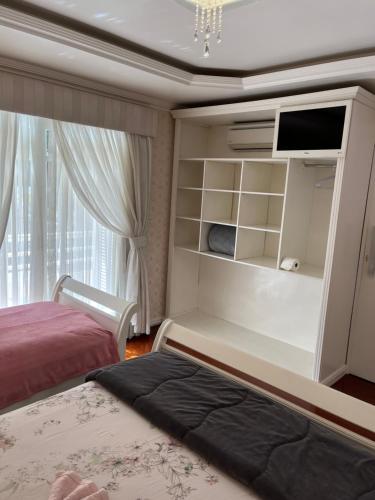 格拉玛多Casa da Fabi的一间卧室设有一张床、一台电视和一个窗口。