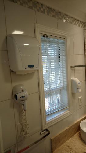 格拉玛多Casa da Fabi的带吹风机的浴室和窗户。