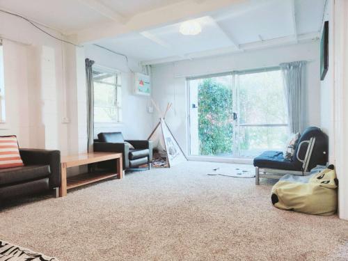 奥克兰Sunny Cosy stay in Auckland的客厅配有家具和大窗户