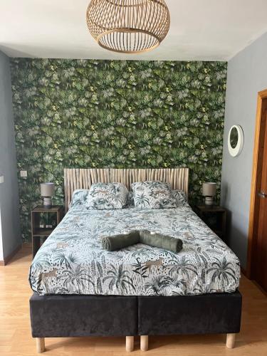 努美阿Studio tropical baie des citrons的一间卧室配有一张带花卉墙壁的床