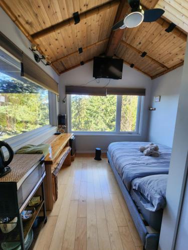 Madeira ParkMadeira Park Oceanview Suites的一间卧室配有一张床和一台平面电视
