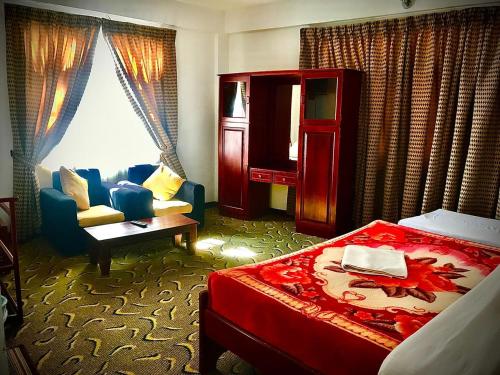 努沃勒埃利耶New Ashley Resorts (PVT) LTD的酒店客房配有一张床、一把椅子和一张沙发