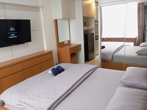 巴淡岛中心SleepRest @ Pollux Habibie的一间卧室配有一张床,墙上配有电视