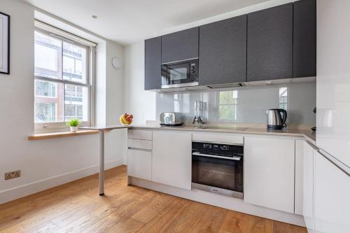伦敦Central Fitzrovia - CityApartmentStay的厨房配有白色橱柜和不锈钢用具