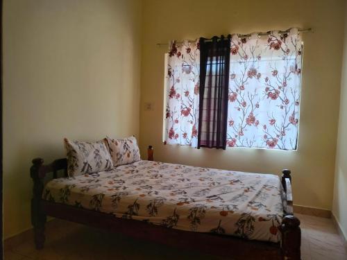 马迪凯里White bungalow的一间卧室配有床和带窗帘的窗户