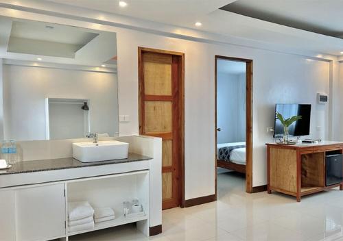 长滩岛The XIMO Suites的一间带水槽和镜子的浴室以及一张床