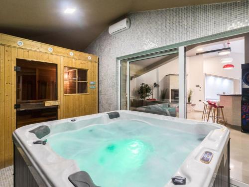 瓦图拉Istra Kamen Comfortable holiday residence的带厨房的客房内的大型热水浴池