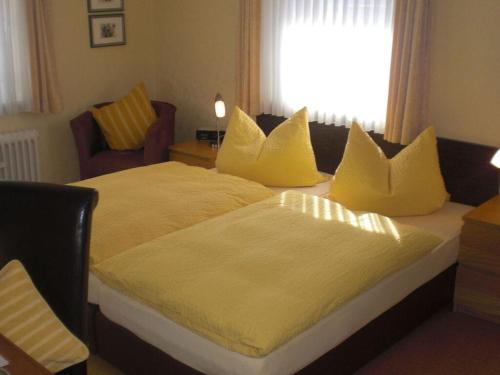 埃斯洛黑Krähenberg Country House的一间卧室配有一张带黄色床单的床和一扇窗户。