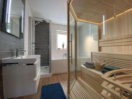 玛库姆Beachvilla Ijsselmeerblik的带淋浴、盥洗盆和浴缸的浴室