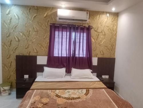 HazārībāgHotel Alakhraj Palace的一间卧室配有一张带紫色窗户的床