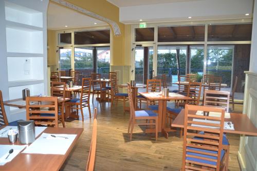 拉奎拉Hotel Azzurro的餐厅设有木桌、椅子和窗户。